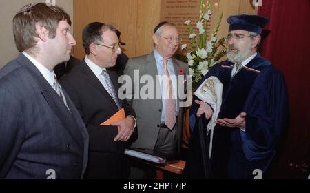 Der Oberrabbiner Jonathan Sacks war Ehrengast bei der Feier des 25th. Jahrestages der hebräischen Kongregation Solihull. Bei seinem Besuch traf er Kinder im Salon einer Familie aus der Gemeinde. Informell spricht er mit jungen jüdischen Kindern über ihre Arbeit im Cheder (Klassenzimmer) der Synagoge, blickt Gemeindepfarr Rabbi Yehuda Pink hin. Er sprach während eines Gedenkgottesdienstes am 27th. Oktober 2002.der Bürgermeister von Solihull Cllr. Kate Wild war dabei und erhielt einen Strauß von der Cheder-Schülerin, 13 Jahre alt, Zipporah Gershon Stockfoto