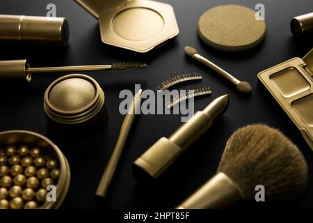 goldene dekorative Make-up Kosmetik auf schwarzem Tisch. Luxus-Beauty-Produkte Konzept Stockfoto