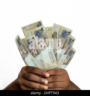 Schwarze Hände mit 3D gerenderten Bahrain-Dinar-Noten. Nahaufnahme der Hände mit Bahrains Währungsbanknoten Stockfoto