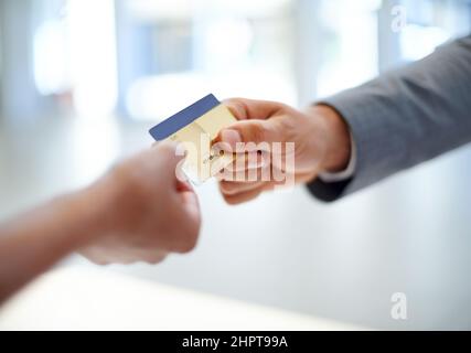 Lege es auf mein Geschäftskonto Nahaufnahme beschnittenes Bild eines Mannes, der einer Frau eine Kreditkarte überreicht. Stockfoto