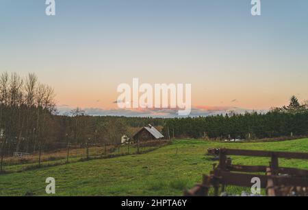 Dramatischer Abendhimmel mit gelbem Mond über der Farm von County Stockfoto