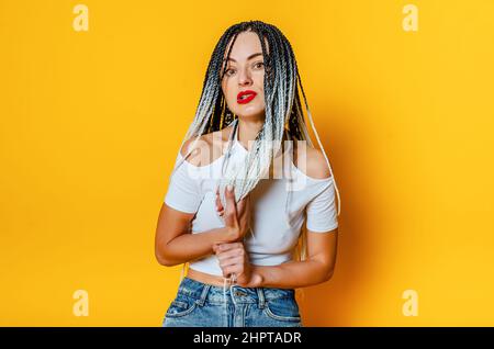 Porträt einer wütenden Frau mit Dreadlocks. Hände halten Dreadlocks. Stockfoto