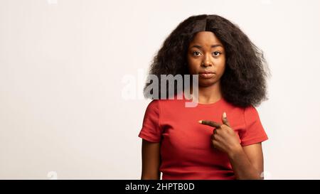 Porträt Einer Verwirrten Jungen Afroamerikanischen Frau, Die Auf Sich Zeigt Stockfoto