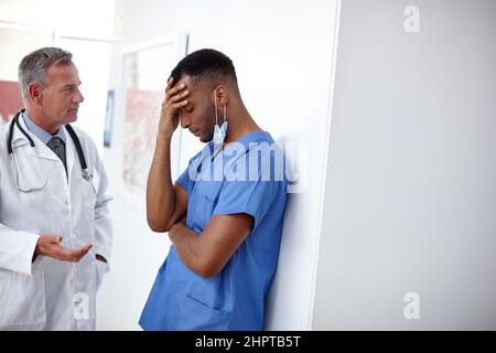 Man hat alles getan, was man konnte. Aufnahme eines Arztes und eines Chirurgen, die ein schwieriges Gespräch führen. Stockfoto