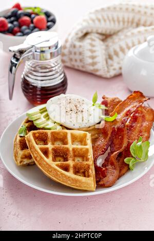 Knusprige belgische Waffeln mit Avocado und Speck zum Frühstück Stockfoto