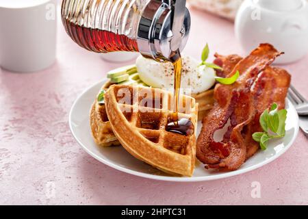 Knusprige belgische Waffeln mit Avocado und Speck zum Frühstück Stockfoto