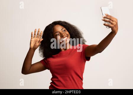 Glückliche Junge Schwarze Frau Mit Smartphone Macht Videoanruf Oder Nimmt Selfie Stockfoto