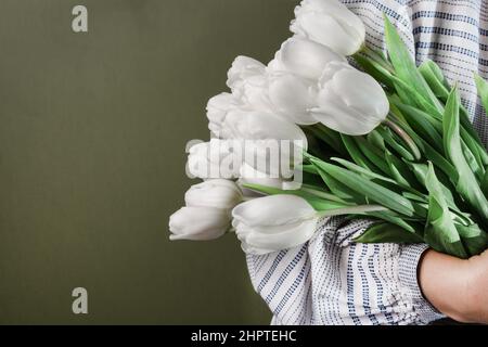 Frau Hände halten Bouquet von weißen Tulpen. Frühlingsblumen aus Tulpen. Blumenpostkarte. Stockfoto