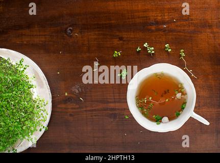 Teetasse mit frischen Kräuterblättern auf Holzhintergrund, Draufsicht, Platz für Text. Gesundes Konzept Stockfoto