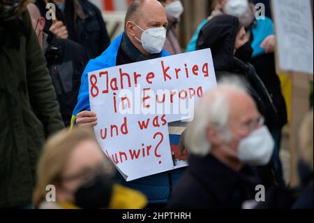 Hamburg, Deutschland. 23rd. Februar 2022. Ein Demonstrator hält ein Plakat mit der Aufschrift „8 Jahre Krieg in Europa und was machen wir?“. Nach Angaben der Polizei versammelten sich am Mittwoch rund 200 Menschen vor dem russischen Generalkonsulat in Hamburg zu einer Solidaritätskundgebung mit der Ukraine. Die Hamburger Jugendorganisationen von SPD, Grünen, CDU und FDP hatten die Kundgebung gefordert. Quelle: Jonas Walzberg/dpa/Alamy Live News Stockfoto