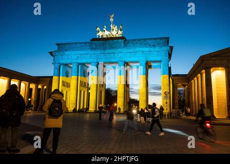 Berlin, Deutschland. 23rd. Februar 2022. Das Brandenburger Tor ist in den Farben der ukrainischen Flagge beleuchtet. Quelle: Christophe Gateau/dpa/Alamy Live News Stockfoto