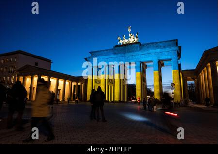 Berlin, Deutschland. 23rd. Februar 2022. Das Brandenburger Tor ist in den Farben der ukrainischen Flagge beleuchtet. Quelle: Christophe Gateau/dpa/Alamy Live News Stockfoto