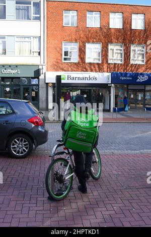 Ein über Eats-Zustellfahrer mit Rucksack wartet in der Stadt Southampton auf seine nächste Lebensmittelzustellung. Stockfoto