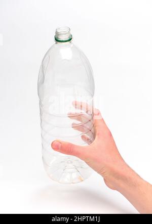 Hand hält eine Einweg-Kunststoff-Getränkeflasche bereit für das Recycling vor einem weißen Hintergrund fotografiert. Stockfoto