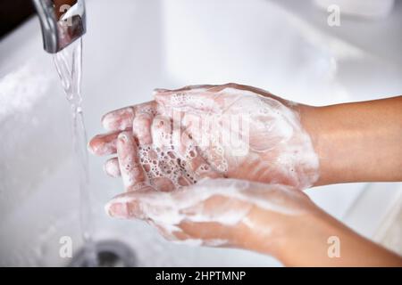 Gute Hygiene - eine tolle Angewohnheit. Eine kurze Aufnahme einer jungen Frau, die sich in ihrem Badezimmer die Hände wusch. Stockfoto