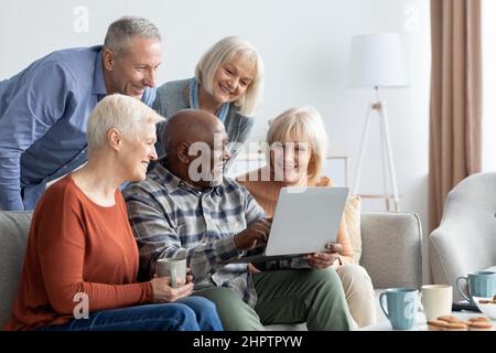 Positive ältere Menschen verbringen zu Hause Zeit mit Gadgets Stockfoto