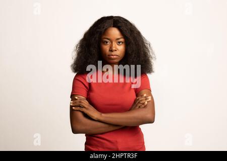 Porträt einer ernsthaften jungen afroamerikanischen Frau, die mit gefalteten Armen steht Stockfoto