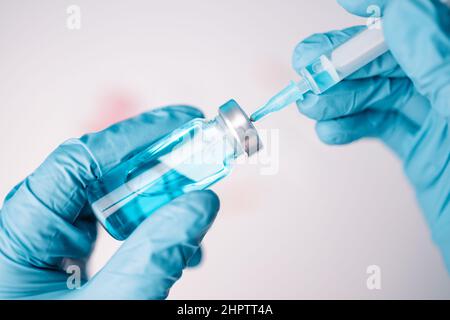 Arzt oder Wissenschaftler, der eine Spritze mit flüssigen Impfstoffen mit Booster-Dosis hält. Impfungen und Impfungen. Stockfoto