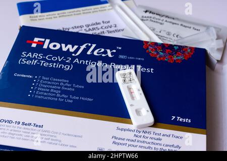 Flowflex SARS-CoV-2 Antigen Rapid Test Kit, Selbsttest, mit einem positiven Ergebnis. Stockfoto