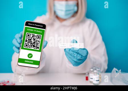 Grünpass des covid-19. Arzthänden mit negativem schnellen lateralen Flow COVID 19-Tests und Mobiltelefon mit Gesundheitspass-App. Impfer Stockfoto