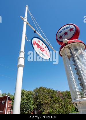 Vintage Imperial Gas Pump: Ein imperiales Schild mit einer alten Gaspumpe hinter einem strahlend blauen Himmel. Stockfoto