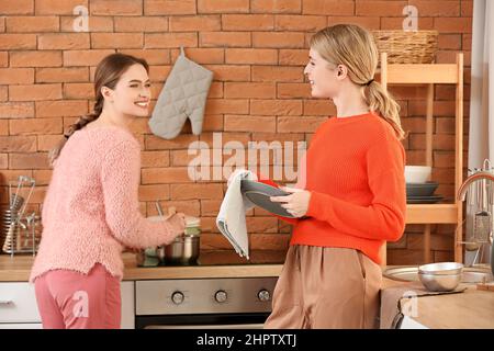 Junge Schwestern waschen Geschirr in der Küche zu Hause Stockfoto