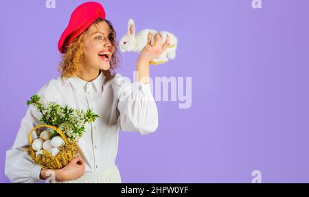 Glückliches Mädchen in Basket mit Eiern und kleinem Hasen. Ostertag. Accessoire für Frauen. Französischer Stil. Stockfoto