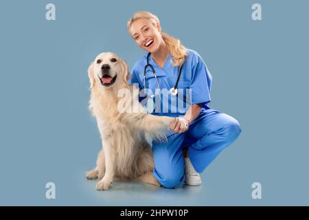 Krankenschwester In Scrubs Uniform Und Stethoskop Posiert Mit Hund Stockfoto