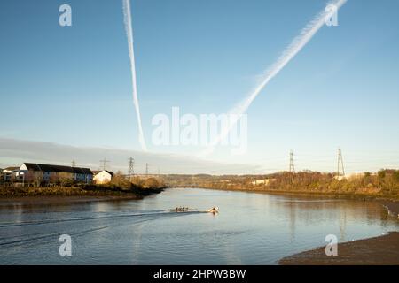 Blaydon auf Tyne Großbritannien: 30th. Januar 2022: Ruderer auf dem Fluss Tyne an einem frühen sonntagmorgen. Rudern Wassersport Übung. Chemtrails am Himmel Stockfoto