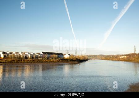 Blaydon auf Tyne Großbritannien: 30th. Januar 2022: Ruderer auf dem Fluss Tyne an einem frühen sonntagmorgen. Rudern Wassersport Übung. Chemtrails am Himmel Stockfoto