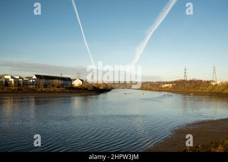 Blaydon auf Tyne Großbritannien: 30th. Januar 2022: Ruderer auf dem Fluss Tyne an einem frühen sonntagmorgen. Rudern Wassersport Übung. Chemtrails am Himmel Stockfoto