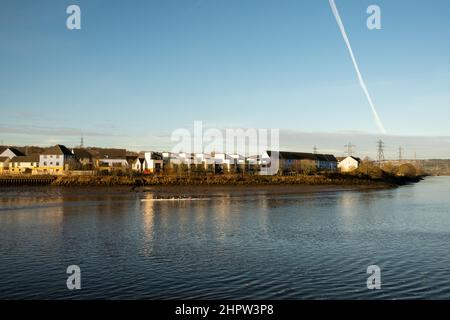 Blaydon auf Tyne Großbritannien: 30th. Januar 2022: Ruderer auf dem Fluss Tyne an einem frühen sonntagmorgen. Rudern Wassersport Übung. Chemtrails am Himmel Stockfoto