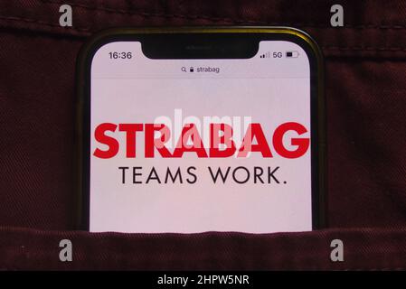 KONSKIE, POLEN - 22. Februar 2022: Das STRABAG SE-Logo wird auf dem Mobiltelefon in der Jeans-Tasche versteckt angezeigt Stockfoto