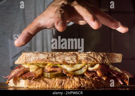 Pastrami-Sandwich auf einer Holztafel mit köstlichen treffen auf Baguette-Brot mit Käse, kopieren Platz in Teilen des Bildes. Stockfoto