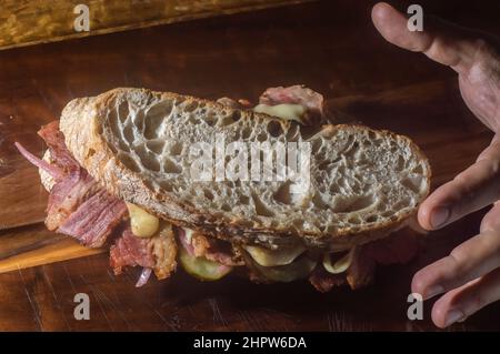 Pastrami-Sandwich auf einer Holztafel mit köstlichen treffen auf Baguette-Brot mit Käse, kopieren Platz in Teilen des Bildes. Stockfoto