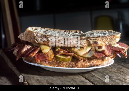 Pastrami-Sandwich auf einer Holztafel mit köstlichen treffen auf Baguette-Brot mit Käse, kopieren Platz in Teilen des Bildes. Stockfoto