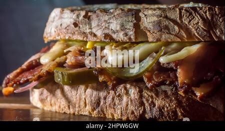 Pastrami-Sandwich auf einer Holztafel mit köstlichen treffen auf Baguette-Brot mit Käse, kopieren Platz in Teilen des Bildes. Stockfoto