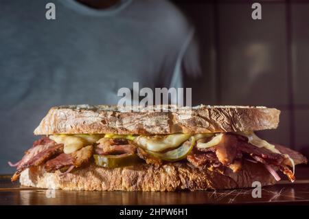 Pastrami-Sandwich auf einer Holztafel mit köstlichen treffen auf Baguette-Brot mit Käse, kopieren Platz in Teilen des Bildes. Stockfoto