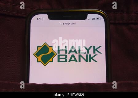 KONSKIE, POLEN - 22. Februar 2022: Das Halyk Bank-Logo wird auf dem Mobiltelefon in der Jeans-Tasche versteckt angezeigt Stockfoto