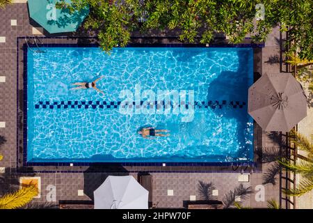 Schwimmer Mann und Frau Paar Tauchen und Schwimmen in der Luxus-Villa Schwimmbad. Luftaufnahme von oben. Sorgloses Konzept für Sommerferien. Stockfoto