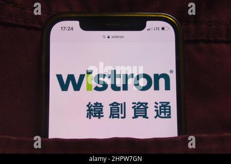 KONSKIE, POLEN - 22. Februar 2022: Das Logo der Wistron Corporation wird auf dem Mobiltelefon angezeigt, das in der Jeanstasche versteckt ist Stockfoto