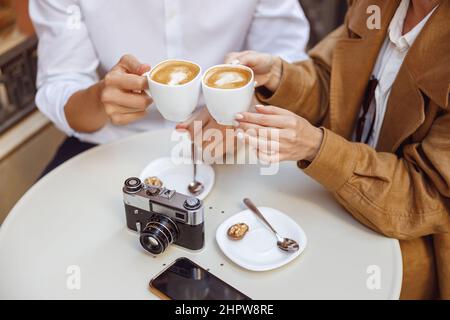 Nahaufnahme der Hände von Mann und Frau, die eine Tasse Kaffee halten Stockfoto