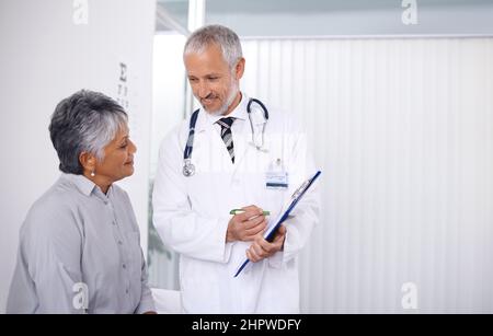 Die Ergebnisse sind sehr positiv. Ein glücklicher Arzt, der sich um einen seiner reifen Patienten gefreut hat. Stockfoto