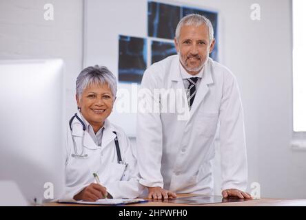 Rücksprache mit einem Kollegen für eine zweite Meinung. Aufnahme von zwei Ärzten, die in einem Krankenhaus zusammenarbeiten. Stockfoto