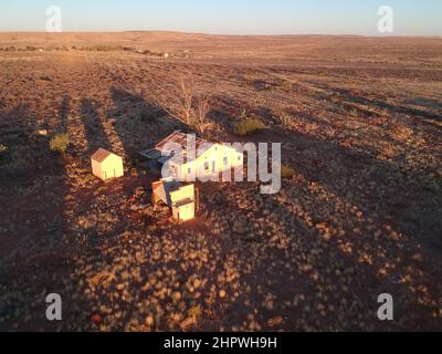 Luftaufnahme der alten Polizeistation, des Nebenhauses und des Gefängnisses im Hintergrund, in einer kleinen Eisenbahnstadt namens Putsonderwater, Geisterstadt in Südafrika. Stockfoto