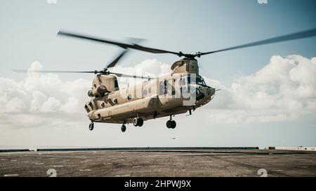 PAZIFISCHER OZEAN (Feb 18, 2022) Ein US Army CH-47F Chinook, der an 3rd Bataillon, 25th Aviation Regiment, 25th Combat Aviation Brigade, angeschlossen ist, bereitet sich auf das Flugdeck des amphibischen Transportdocks USS Portland (LPD 27) vor, während er Decklandungen durchführt, 18. Februar. Marineinfanteristen und Matrosen der Marine Expeditionary Unit 11th und der Amphibious Ready Group Essex führen Routineoperationen in der US-Flotte der 3rd durch. (USA Marine Corps Foto von Gunnery Sgt. Donald Holbert) Stockfoto