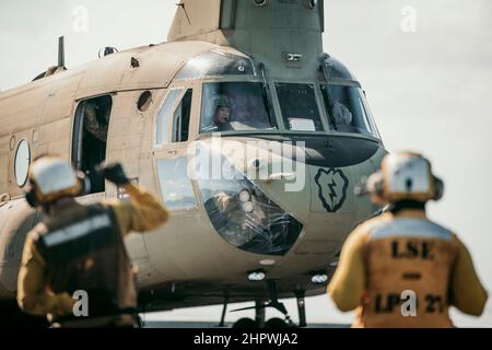 PAZIFISCHER OZEAN (Feb 18, 2022) Ein US Army CH-47F Chinook, der an das 3rd Bataillon, 25th Aviation Regiment, 25th Combat Aviation Brigade, angeschlossen ist, sitzt auf dem Flugdeck des Amphibientransportsdocks USS Portland (LPD 27), während er Decklandungen durchführt, 18. Februar. Marineinfanteristen und Matrosen der Marine Expeditionary Unit 11th und der Amphibious Ready Group Essex führen Routineoperationen in der US-Flotte der 3rd durch. (USA Marine Corps Foto von Gunnery Sgt. Donald Holbert) Stockfoto