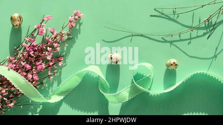 Frühling Ostern Panorama Banner Hintergrund in mintgrün. Rosa Blumen, Freesie, Wachteln Ostereier. Stockfoto