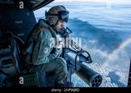 U.S. Marine Corps Sgt. William Ton, ein Crewchef, der dem Marine Attack Light Attack Helicopter Squadron 469, Marine Aircraft Group 39, 3rd Marine Aircraft Wing (MAW), zugewiesen wurde, weist die Piloten während eines Hubschrauberbesuchs, eines Boards, einer Suche, auf ihre Distanz zu einem Range Support Craft hin. Und Beschlagnahmentraining auf einem UH-1Y Venom vor der Küste von San Clemente Island, Kalifornien, 17. Februar 2022. Winter Fury 22 bietet den Marines von 3rd MAW realistische, relevante Ausbildungsmöglichkeiten, die notwendig sind, um auf jede Krise auf der ganzen Welt zu reagieren und in einem hart umkämpften Seekonflikt entschieden zu gewinnen. (U Stockfoto