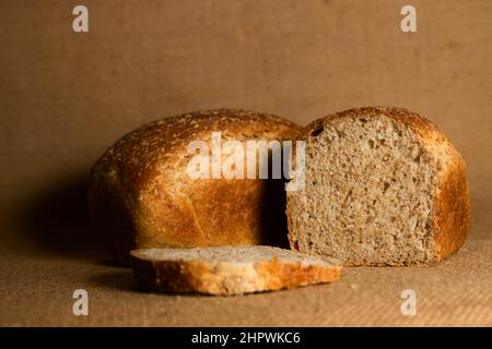 Foto eines Paares hausgemachtem Vollkornmehl-Brot auf einem braunen Sackleinen-Tuch, das Platz für die Kopie lässt Stockfoto